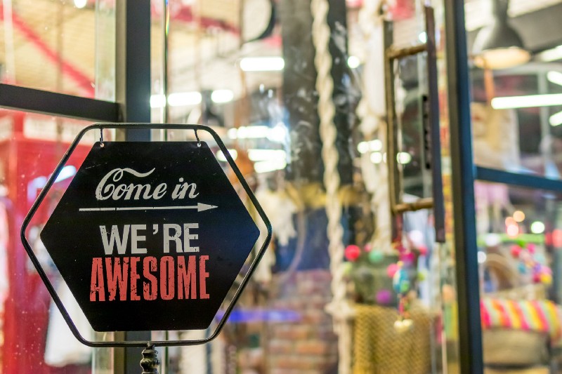 A sign on a store door that says, “Come in, we’re awesome.”